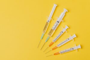 Syringes of different sizes on yellow background